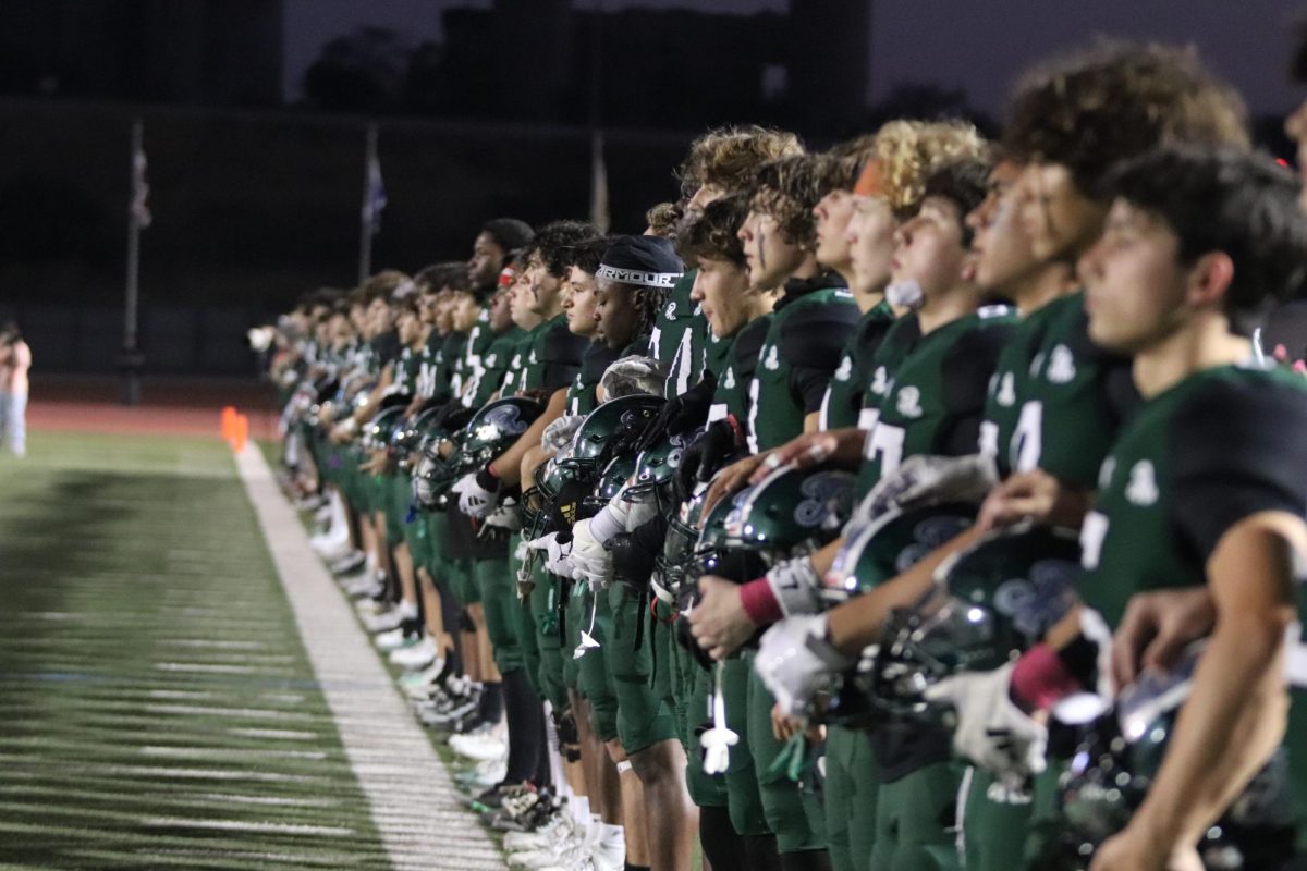 Varsity football team locked arms as they prepared to face the Johnson Jaguars on Friday at Comalander Stadium. 