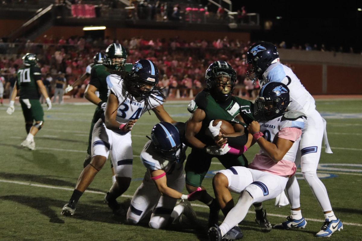 Varsity player Cole Pryor gets taken down in his attempt to score a touchdown during Friday's Pink Out game against Johnson High School.