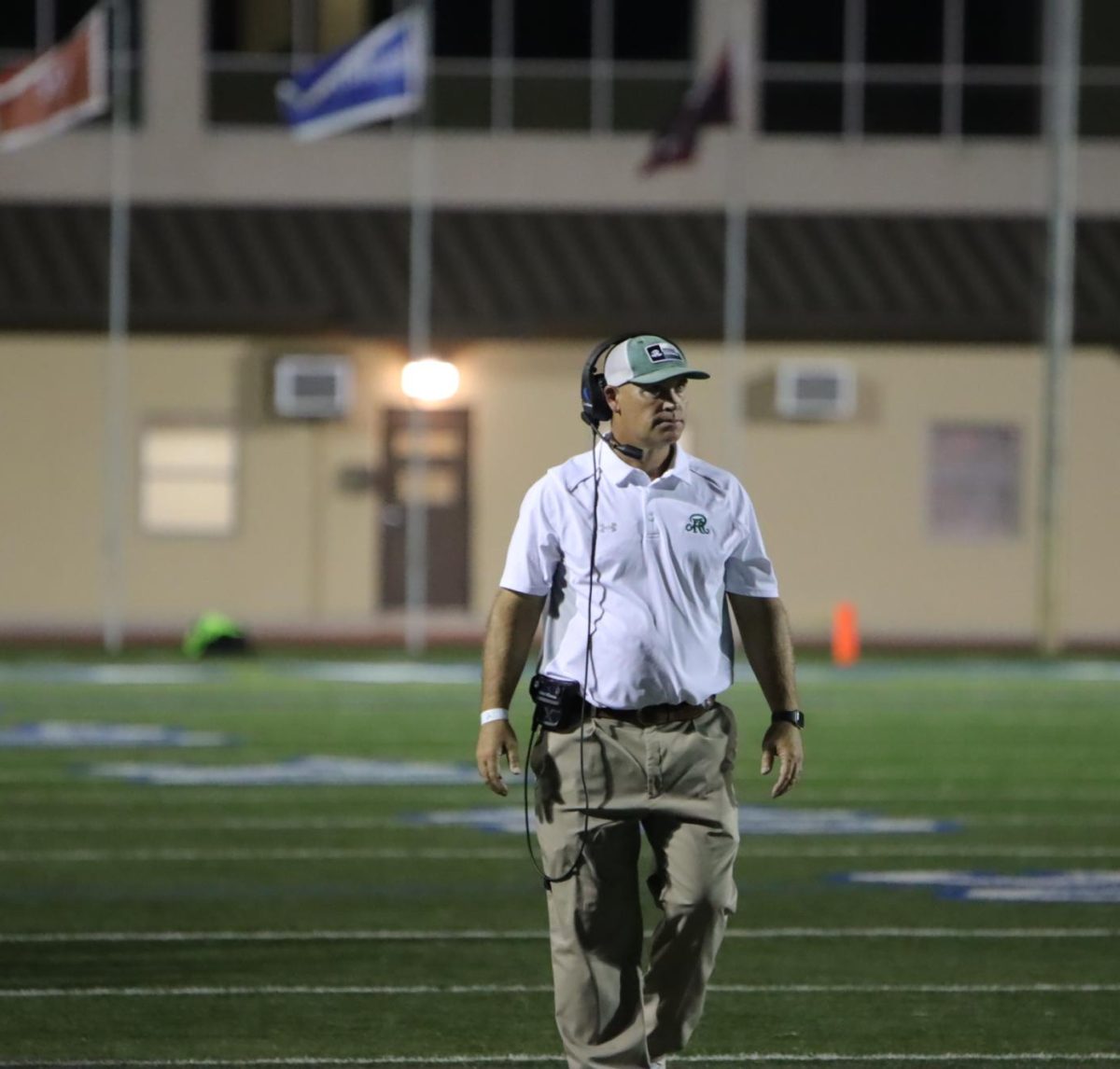 Coach Ham walking on the sidelines during the Temple VS Reagan Football game.