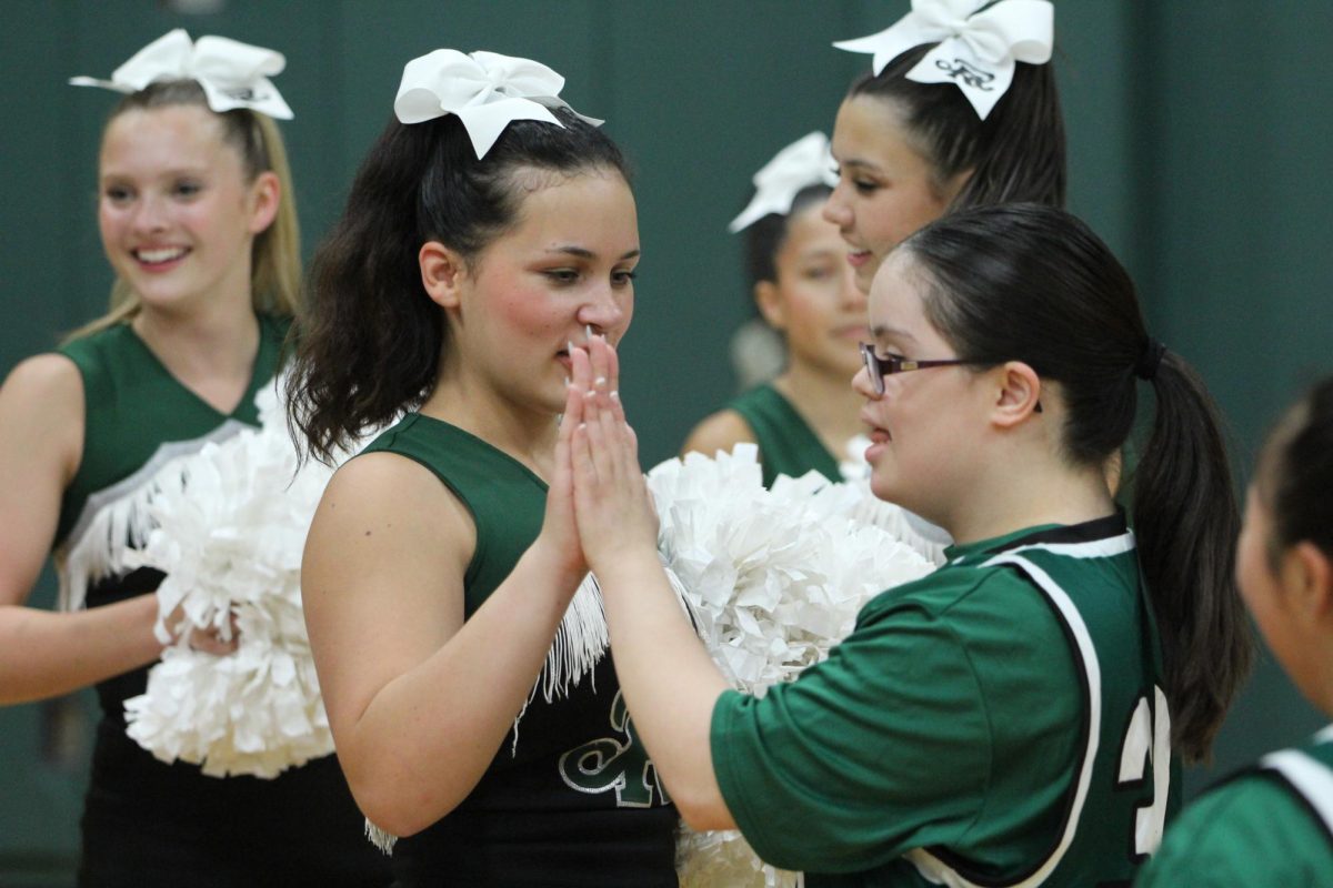 Mia Pablos getting a high five from one of the cheerleaders before the Special Olympics basketball game.