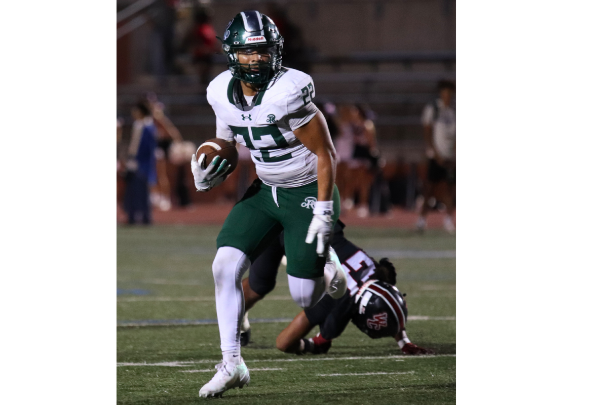 Varsity Football Linebacker Ayden Fernandez makes a run for it with ball in hand.
