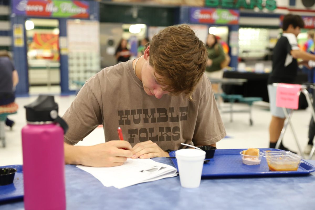 Senior Zachary Hopkins filling out the feedback packet after testing the breakfast menu.