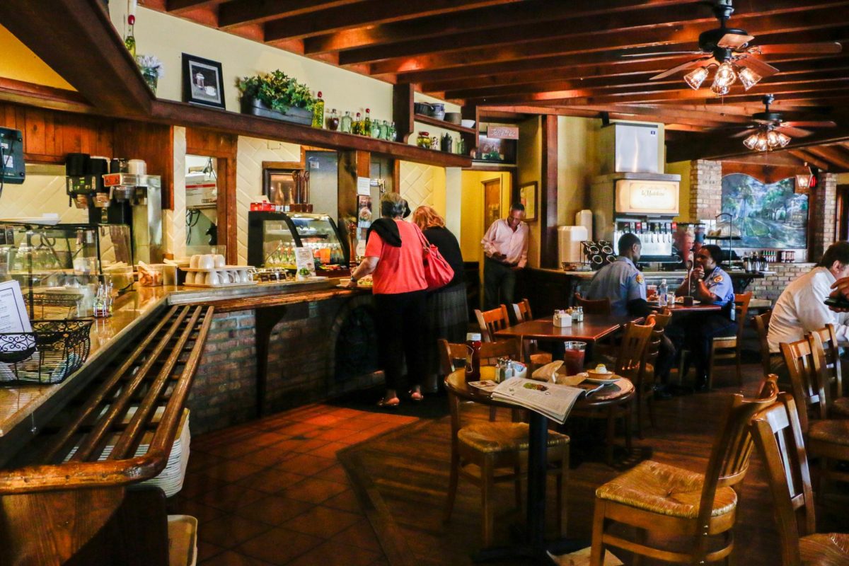Customers dine inside La Madeleine as warm lighting, rustic décor and French-inspired details create a cozy café atmosphere on U.S. Highway 281.