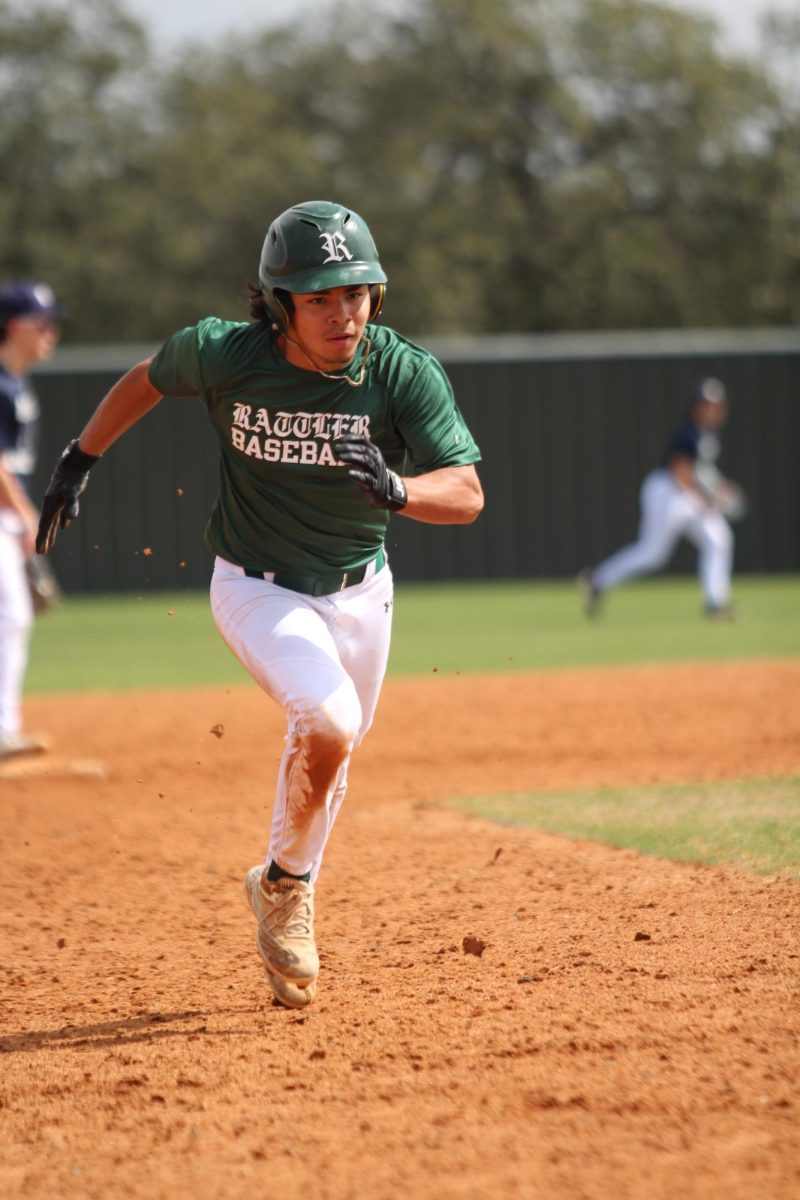 FILE – A Reagan JV baseball player sprints toward home plate during a game.